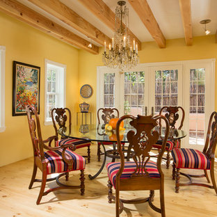 Diseño de comedor de estilo americano, sin chimenea, con paredes amarillas y suelo de madera clara