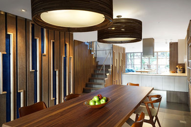 Immagine di una grande sala da pranzo aperta verso la cucina contemporanea con pavimento in gres porcellanato e pavimento grigio