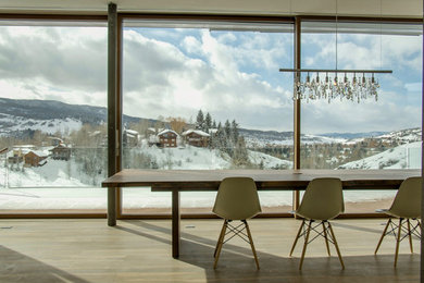 This is an example of a large modern kitchen/dining room in Denver with white walls, light hardwood flooring and beige floors.