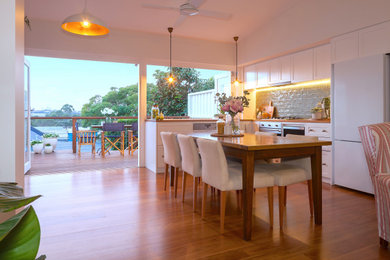 Ejemplo de comedor clásico abierto con paredes blancas, suelo de madera en tonos medios y suelo marrón