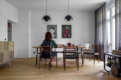 Imagen de comedor retro de tamaño medio abierto con paredes blancas, suelo de madera en tonos medios y suelo marrón