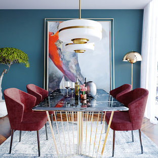 Example of an eclectic medium tone wood floor and brown floor dining room design in New York with blue walls
