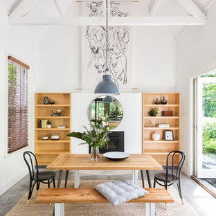 Design ideas for a country dining room in Melbourne with white walls, concrete floors, a standard fireplace and grey floor.