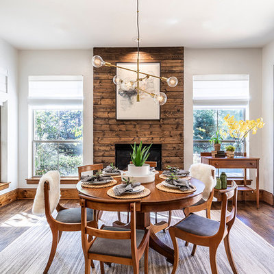Inspiration for a scandinavian dark wood floor and brown floor dining room remodel in Dallas with white walls, a standard fireplace and a wood fireplace surround