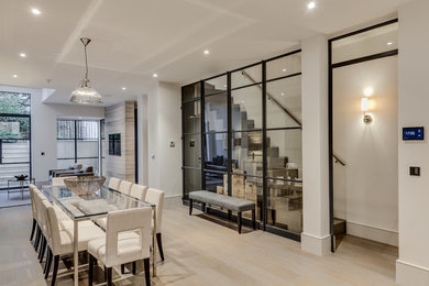 Photo of a medium sized contemporary open plan dining room in London with no fireplace and beige floors.