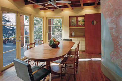 Imagen de comedor minimalista de tamaño medio cerrado sin chimenea con paredes amarillas, suelo de madera en tonos medios y suelo beige