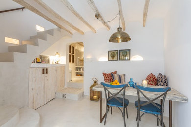 Immagine di una piccola sala da pranzo aperta verso il soggiorno mediterranea con pareti bianche