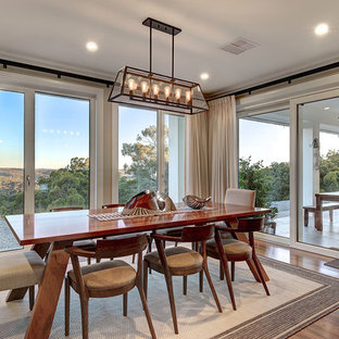 Photo of an expansive country kitchen/dining combo in Adelaide with beige walls, medium hardwood floors and brown floor.