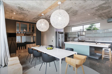 Imagen de comedor de cocina actual de tamaño medio con paredes multicolor y suelo de cemento