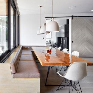 Inspiration for a contemporary kitchen/dining room in London with white walls, light hardwood flooring and grey floors.