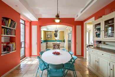 This is an example of a classic dining room in Other with orange walls.