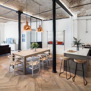 Photo of an urban kitchen/dining room in London with white walls, medium hardwood flooring and brown floors.