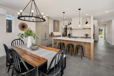 Ejemplo de comedor de estilo de casa de campo grande abierto con paredes blancas, suelo de cemento y suelo gris