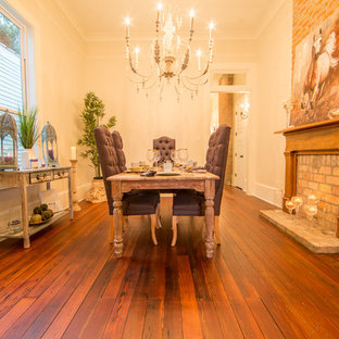 Esempio di una sala da pranzo vittoriana chiusa e di medie dimensioni con pareti bianche, parquet scuro, camino classico e cornice del camino in mattoni