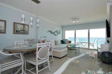 Example of a mid-sized beach style porcelain tile and beige floor enclosed dining room design in Miami with blue walls and no fireplace