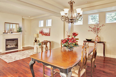 Example of a tuscan dark wood floor dining room design in Seattle with beige walls, a standard fireplace and a stone fireplace