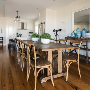 Beach style open plan dining in Melbourne with white walls, medium hardwood floors and brown floor.