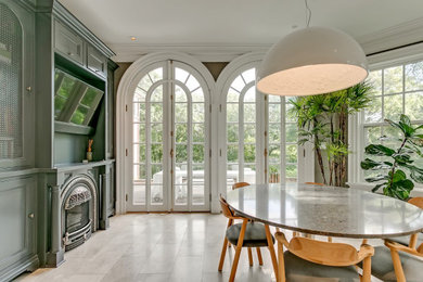 Mid-sized ornate marble floor and beige floor kitchen/dining room combo photo in Toronto with gray walls, a standard fireplace and a metal fireplace