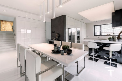 Immagine di una sala da pranzo aperta verso la cucina minimalista di medie dimensioni con pareti bianche e pavimento bianco