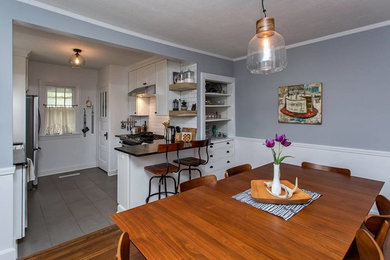Exemple d'une salle à manger ouverte sur la cuisine chic de taille moyenne avec un mur gris, parquet foncé, aucune cheminée et un sol gris.