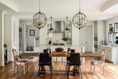 Foto di un'ampia sala da pranzo aperta verso la cucina classica con pareti bianche e pavimento in legno massello medio