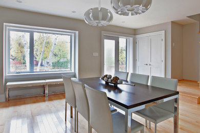 Modelo de comedor de cocina minimalista con paredes grises y suelo de madera clara