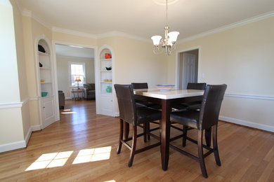 Example of a medium tone wood floor enclosed dining room design with beige walls and no fireplace