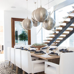 Inspiration pour une grand salle à manger design fermée avec un mur blanc, un sol en calcaire, une cheminée double-face et un manteau de cheminée en carrelage.