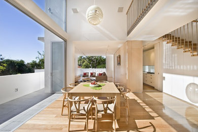 Inspiration for a large contemporary open plan dining room in Sydney with white walls and light hardwood flooring.