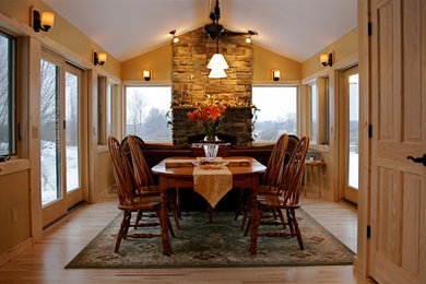 Example of a mid-sized classic light wood floor and beige floor enclosed dining room design in Detroit with beige walls, a standard fireplace and a stone fireplace
