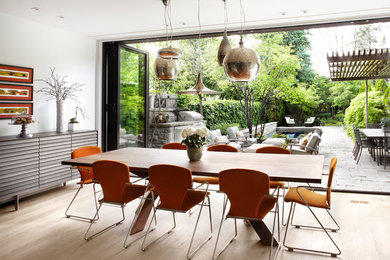 This is an example of a contemporary dining room in Toronto with white walls and light hardwood flooring.