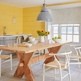 Imagen de comedor de cocina campestre, de tamaño medio, con paredes amarillas, suelo gris y suelo de madera clara