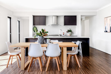 Réalisation d'une salle à manger ouverte sur la cuisine design de taille moyenne avec aucune cheminée, un mur gris, parquet clair et un sol marron.
