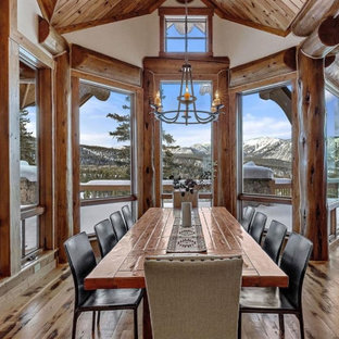 Esempio di un'ampia sala da pranzo aperta verso il soggiorno stile rurale con pareti beige, parquet chiaro, camino classico, cornice del camino in pietra, pavimento beige e soffitto a volta
