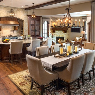 Ispirazione per una grande sala da pranzo aperta verso la cucina chic con parquet scuro, camino ad angolo e cornice del camino in pietra