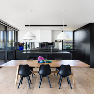Design ideas for a contemporary kitchen/dining combo in Melbourne with white walls, light hardwood floors and beige floor.