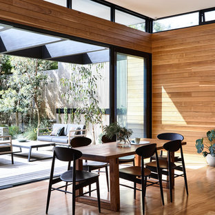 Idee per una sala da pranzo aperta verso la cucina design di medie dimensioni con pareti marroni, pavimento in legno massello medio e pavimento arancione