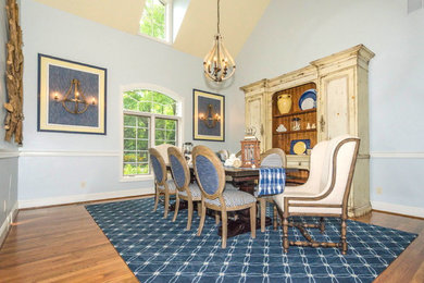 Aménagement d'une grande salle à manger classique avec un mur bleu et parquet foncé.