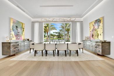 Large trendy light wood floor, beige floor and coffered ceiling great room photo in Miami with white walls, a two-sided fireplace and a stone fireplace
