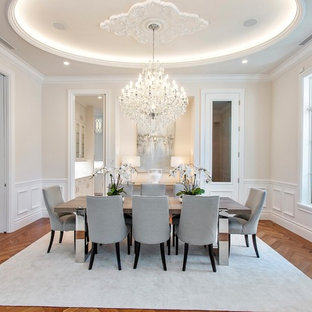 Foto di una sala da pranzo mediterranea chiusa con pareti beige, pavimento in legno massello medio e nessun camino