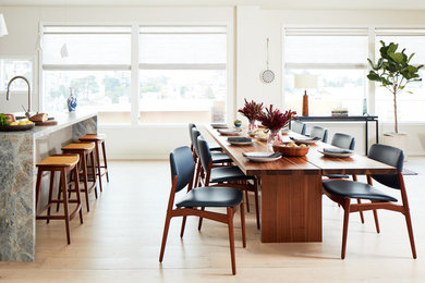 Diseño de comedor contemporáneo abierto con paredes blancas y suelo de madera clara