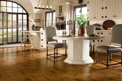 Imagen de comedor campestre de tamaño medio abierto con paredes blancas, suelo de madera en tonos medios y suelo marrón