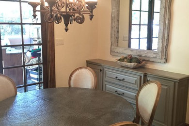 Cette photo montre une salle à manger ouverte sur la cuisine chic avec un mur beige et un sol en travertin.