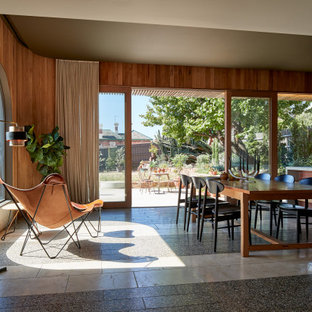 Industrial dining room in Sydney with brown walls, grey floor and wood walls.
