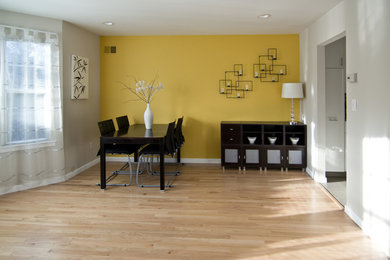 Inspiration for a small enclosed dining room in New York with white walls and light hardwood flooring.