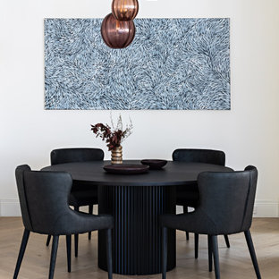 Idée de décoration pour une salle à manger design avec un mur jaune, un sol en bois clair et un sol beige.