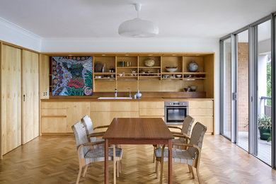 Diseño de comedor escandinavo cerrado con paredes blancas, suelo de madera clara y suelo beige