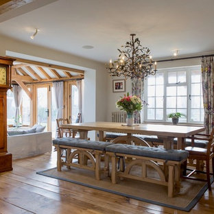 Inspiration for a farmhouse dining room in Hampshire with beige walls, medium hardwood flooring and brown floors.