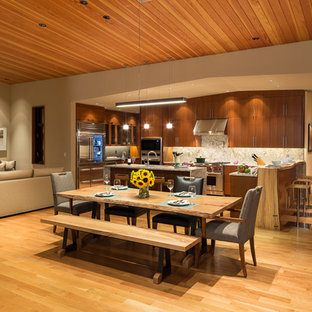 Esempio di una grande sala da pranzo aperta verso la cucina design con pareti beige, pavimento in legno massello medio, camino classico, cornice del camino piastrellata e pavimento marrone