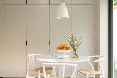 Foto di una sala da pranzo aperta verso la cucina scandinava di medie dimensioni con parquet chiaro, pavimento bianco e pareti grigie